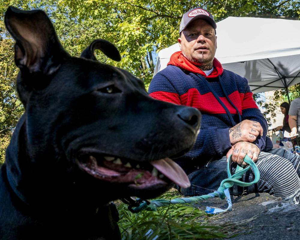 <p>Patrick Stephens, 43, of Lansing, sits with his 9-month-old pit bull, Melly, during a free veterinary clinic hosted by the Michigan Community Street Clinic at Reutter Park in Lansing, Mich., on Sunday, Sept. 27, 2026. “He was smelly when I got him, so I dropped the ‘S’ and named him Melly,” Stephens said.</p>