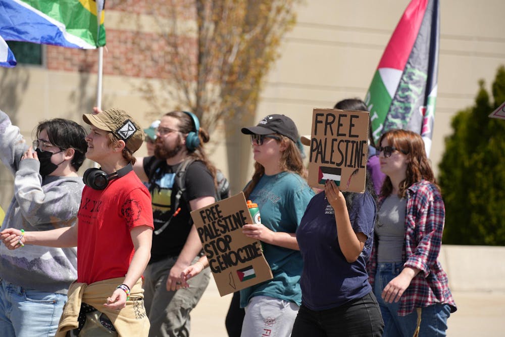 MSU student protestors march from the Gaza solidarity encampment to the Breslin Center on April 26, 2024. They planned to picket the spring convocation ceremony at Breslin. 