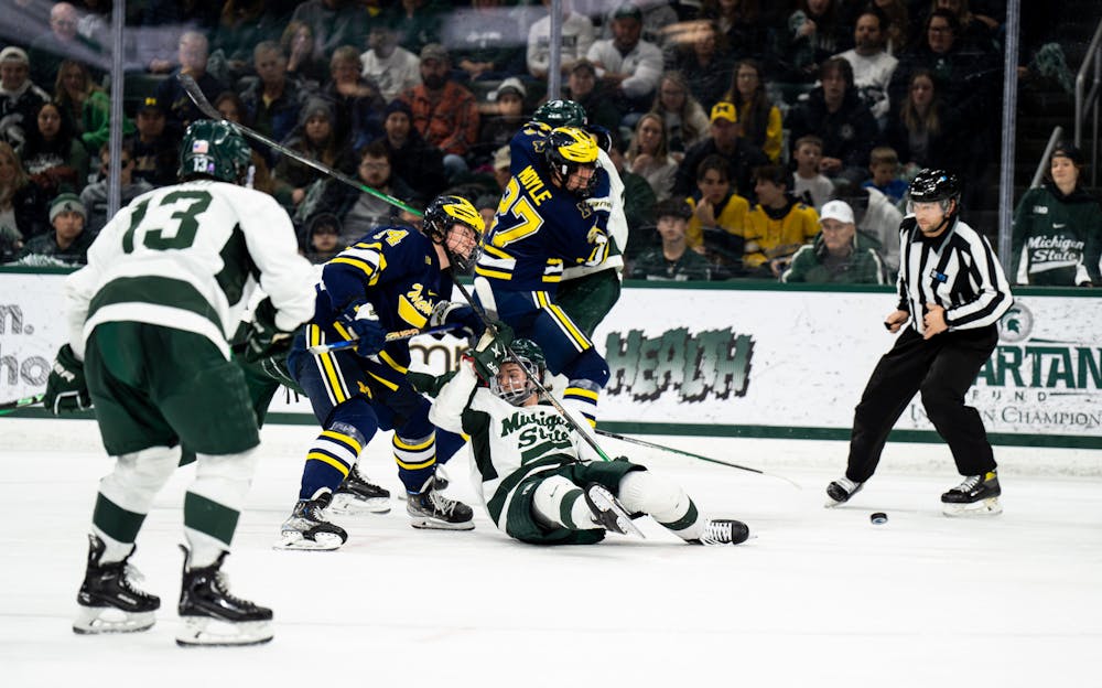 Senior forward Nicolas Müller (19) falls on the ice during a game against the University of Michigan at Munn Ice Arena on Dec. 9, 2022. The Spartans defeated the Wolverines 2-1. 