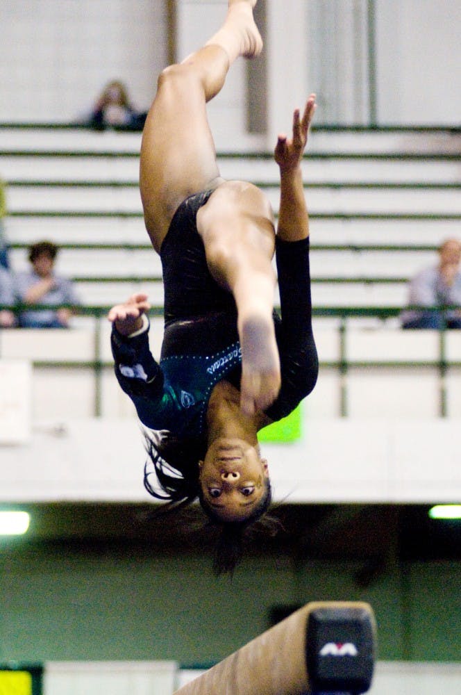 Redshirt freshman Taira Neal flips on the balance beam Friday night at Jenison Field House. The MSU gymnastics team narrowly lost to Illinois, 195.225 to 195. Matt Hallowell/The State News