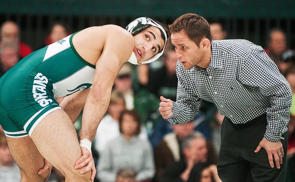 	<p>Assistant coach Chris Williams, right, and sophomore 184-pounder John Rizqallah talk during a meet on Jan. 20, 2013, at Jenison Field House. Rizqallah beat Iowa&#8217;s Ethen Lofthouse 6-3. Julia Nagy/The State News</p>