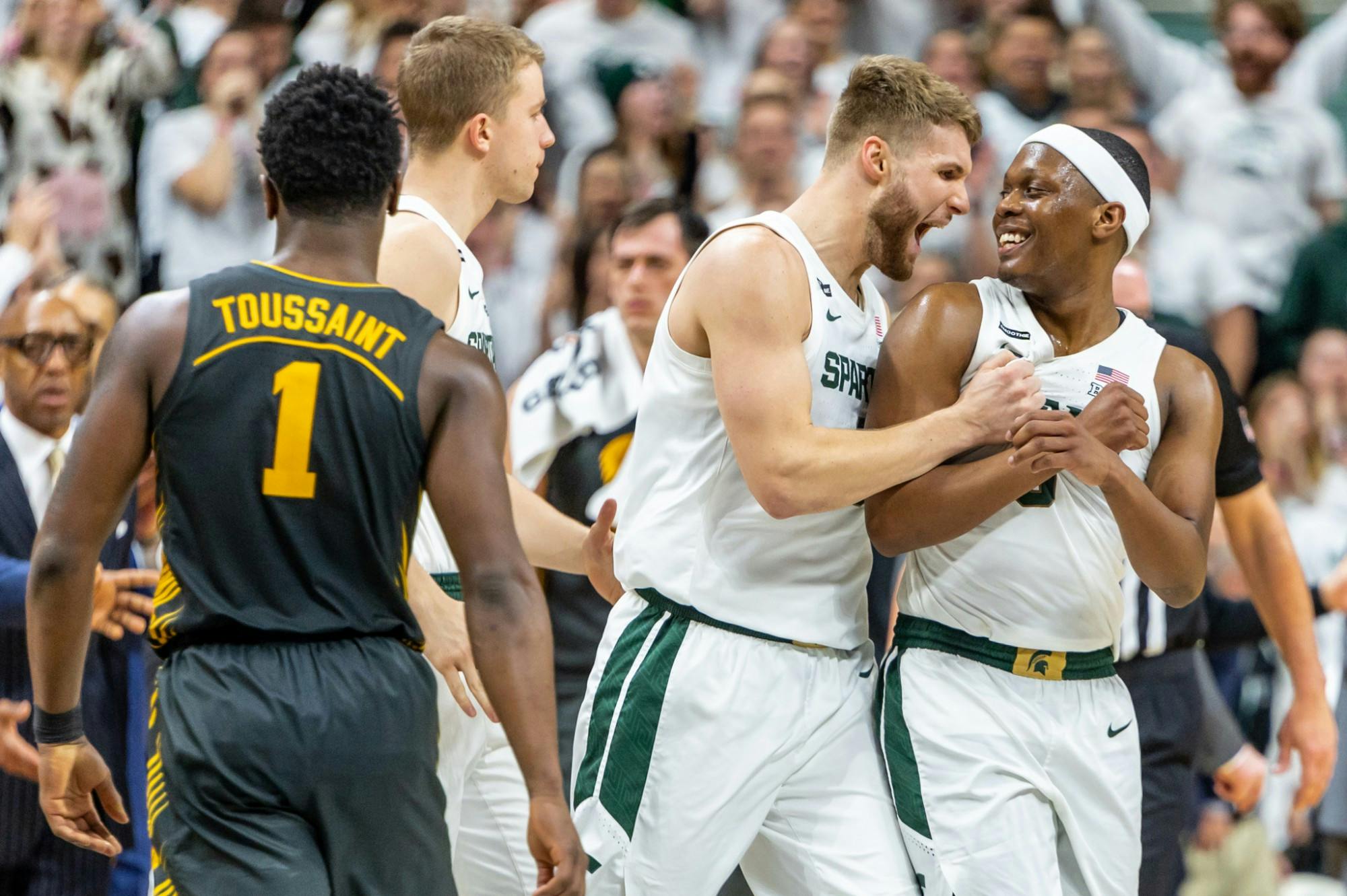 Senior forward Kyle Ahrens (left) celebrates retaking the lead with senior guard Cassius Winston (right) during a game against Iowa. The Spartans defeated the Hawkeyes, 78-70, at the Breslin Student Events Center on February 25, 2020. 
