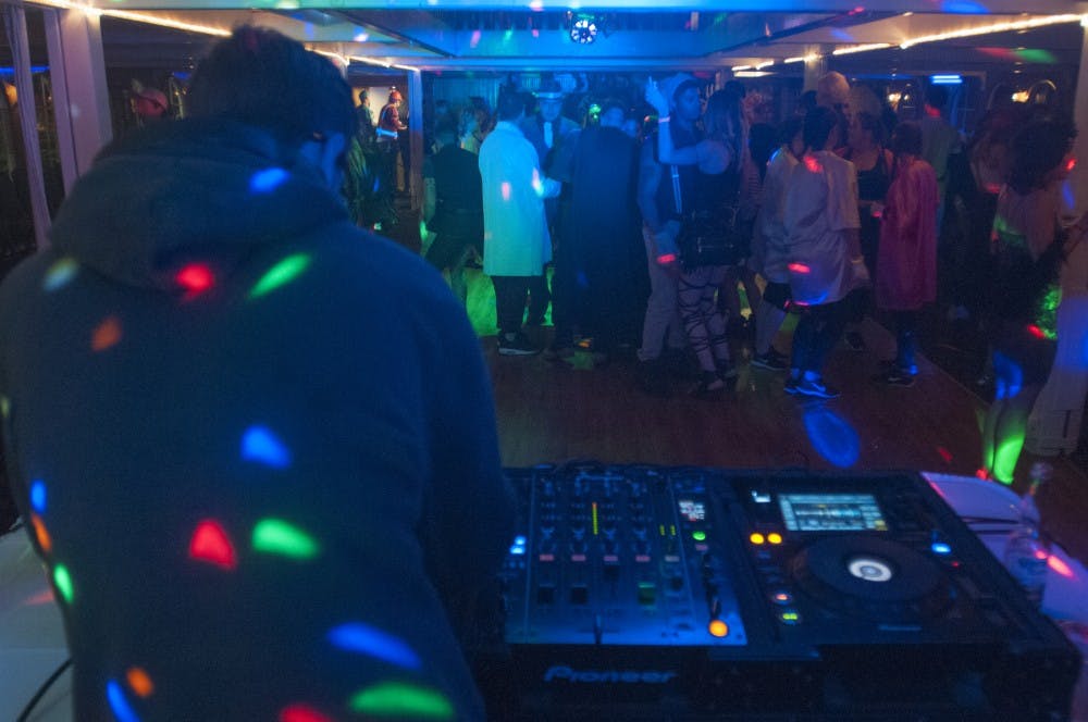 Lansing resident Addison Brown plays music while partygoers dance on Oct. 26, 2016 onboard the Michigan Princess. Brown, who goes by VADR, was the DJ for the Princess's last all college student night.