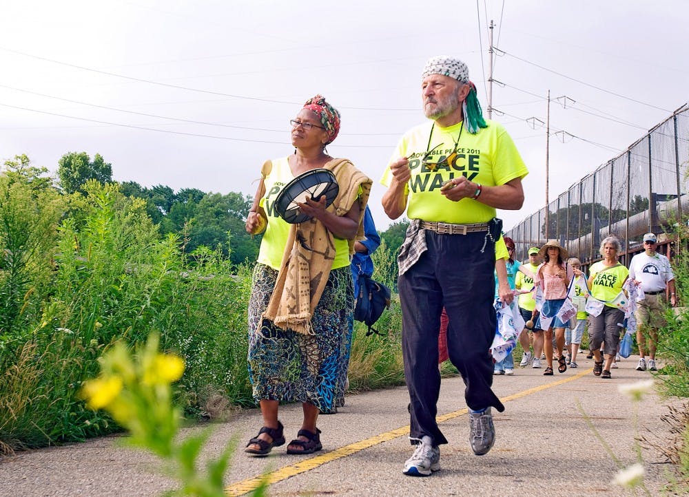 	<p>Ferndale, Mich. resident, Ruby Woods beats a hand-held drum alongside Yusif Barakat, a long-displaced Palestinian now residing in Pinckney, Mich., during the Peace Walk along the Lansing River Trail.  People rallied for peace at the capitol Tuesday morning, many of whom walked to Lansing from Grand Rapids, Saginaw or Detroit, Michigan. </p>