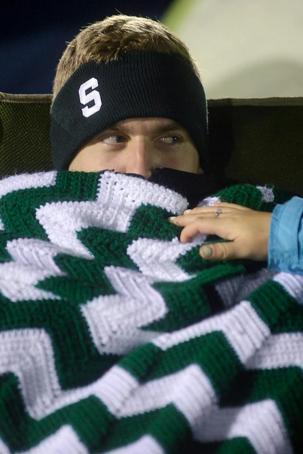 <p>Finance junior Patrick Price glares at child development junior Ashley Beyer as she tries to lower his blanket Oct. 17, 2014, during the Izzone Campout at Munn Field. Hundreds of students battled the cold and rain to sleep outdoors overnight in hopes of getting lower bowl seating. Julia Nagy/The State News</p>