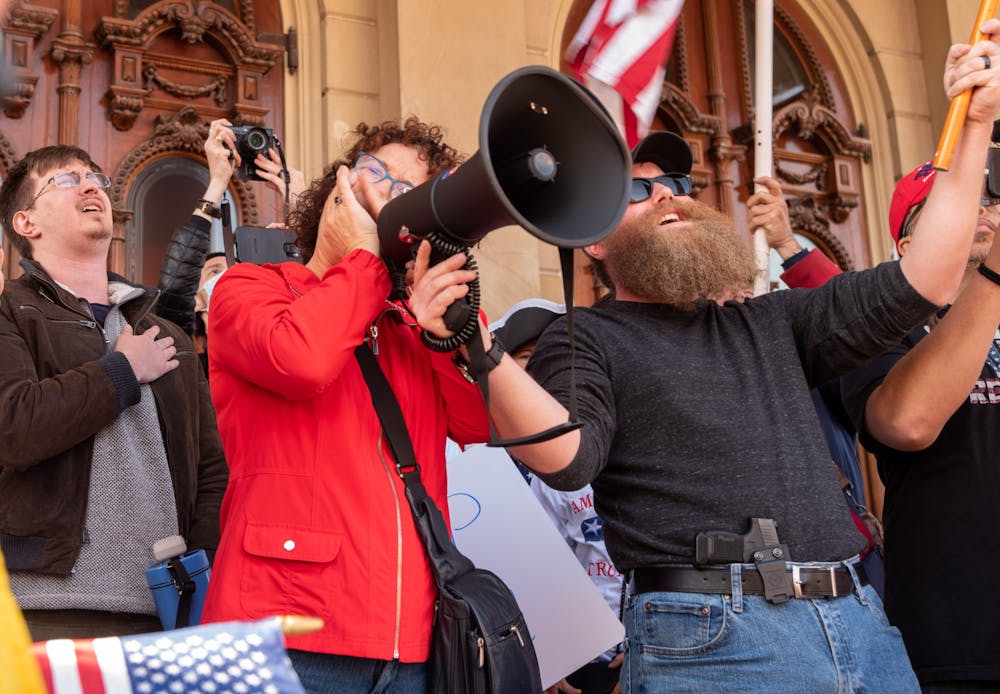 <p>Ester, an Amish woman from Michigan playing the national anthem with the harmonica on the Michigan State Capital steps at the Stop The Steel Rally on Saturday, November, 7, 2020.</p><p> </p>