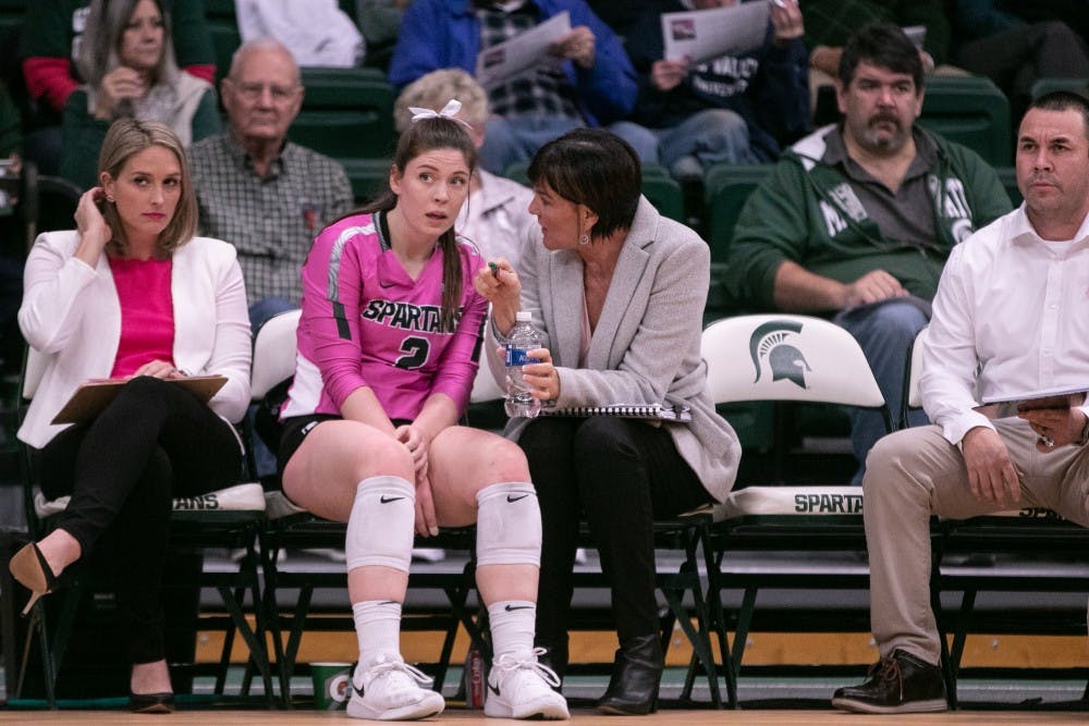 <p>Graduate setter Audrey Alford (2) listens to Head Coach Cathy George during their game against Wisconsin on Oct. 25, 2019, at Jenison Fieldhouse. The Spartans fell to the Badgers, 0-3.</p>