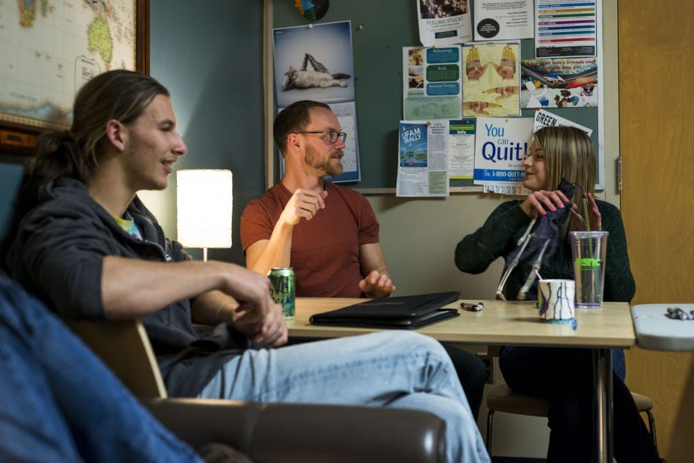 Graduate student Emily Young, right, grabs the talking skeleton from East Lansing resident Greg Dagner, center, during the MSU Traveler's Club meeting on March 31, 2017 at Olin Health Center. The MSU Traveler's Club is a club that provides a social space and support for people who are in recovery from addiction. 
