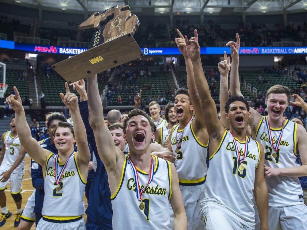 Clarkston senior guard Foster Loyer (1) hoists the championship trophy after he and his team won the Class A boys basketball state final against Holland West Ottawa on March 24, 2018 at Breslin Center in East Lansing. Clarkston defeated Holland West Ottawa, 81-38. (Nic Antaya | The State News)