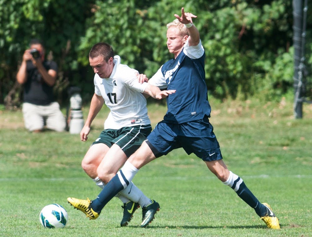 Junior midfielder Kyle Rutz, 17, tries to keep Connecticut junior midfielder Juho Karppinen from stealing the ball during a home game on Monday, Sept. 3, 2012, at DeMartin Stadium. The Spartans lost 1-0. Julia Nagy/The State News