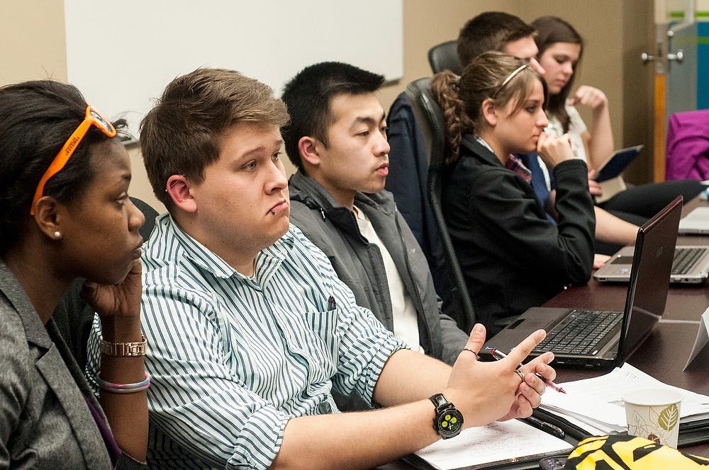 	<p>Communication and public relations junior Greg Rokisky, center left, and food industry management junior Kevin Chung, center right, watch as a presentation is given during the <span class="caps">ASMSU</span> meeting March 28, 2013, at Student Services. <span class="caps">ASMSU</span> meets on a weekly basis to discuss issues on campus and throughout the community. Katie Stiefel/ The State News</p>