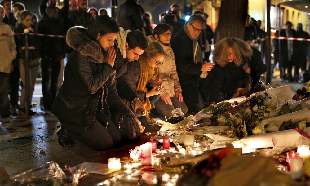 <p>At the Le Bataclan Theater in Paris, people bring flowers to a memorial at a nearby street corner on Saturday, Nov. 14, 2015, as France declares a state of emergency after at least 120 people were killed in gun and bomb attacks. (Carolyn Cole/Los Angeles Times/TNS)</p>