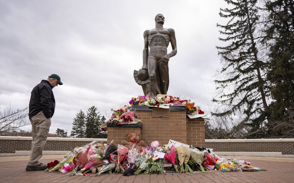 Flowers rest at the foot of the Spartan statue on Wednesday, Feb. 15, 2023 - two days after the mass shooting in Michigan State University’s north campus. Memorials have spread across campus in honor of Brian Fraser, Alexandria Verner and Arielle Anderson, the three killed on Feb. 13. 