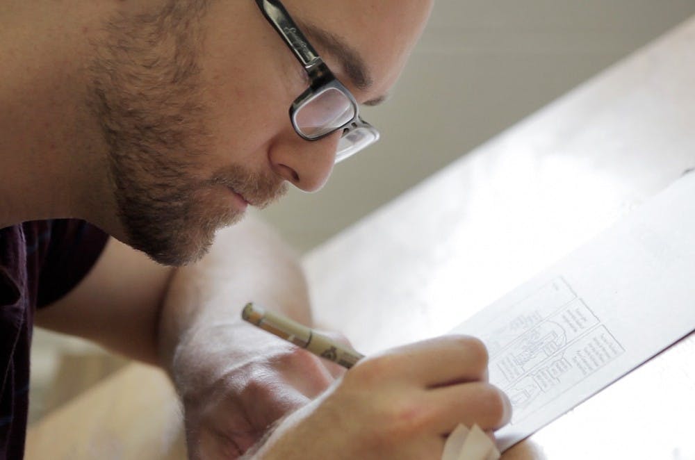 	<p>Artist Ryan Claytor works on a comic Sept. 18, 2013, at his office in the Urban Planning and Landscape Architecture Building. Claytor produces a series of autobiographical comics called &#8220;And Then One Day.&#8221; Julia Nagy/The State News</p>