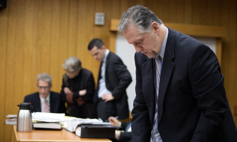 Assistant Attorney General Scott Teter sorts through documents at a preliminary hearing at Eaton County District Court April 16, 2019. Simon is charged with four counts of lying to a peace officer, including two felonies.