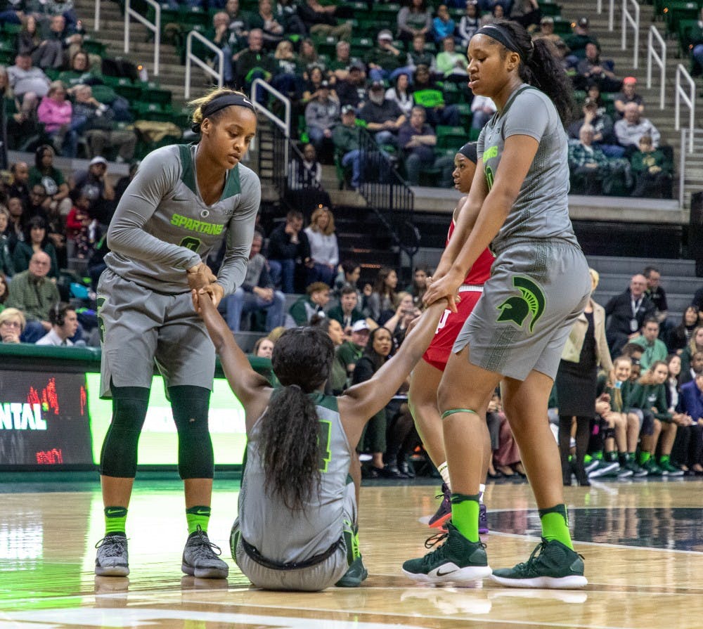 Redshirt junior guard Shay Colley (0) and Freshman forward Sidney Cooks (10) help up Freshman guard Nia Clouden (24) during the game against Indiana on Feb.11, 2019. The Spartans lead the Hoosiers 33-30 at halftime.