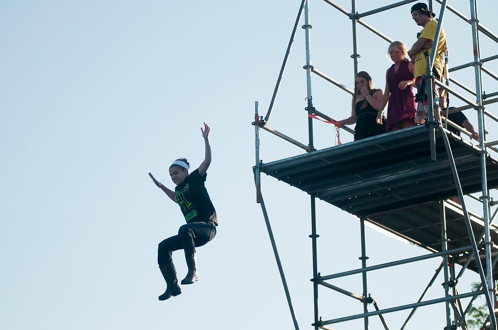 	<p>Eaton Rapids, Mich., resident Elizabeth Olin, 15, jumps of a platform onto a giant inflatable at Common Ground Music Festival on July 11, 2013, at Adado Riverfront Park in Lansing. &#8220;I&#8217;m still shaking,&#8221; Olin said about the jump. Julia Nagy/The State News </p>