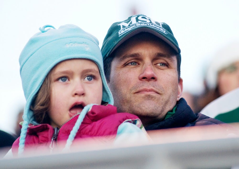 Brian Smith, a professor teaching medicine at MSU, sits with his daughter Hannah, 5, Tuesday at Cooley Law School Stadium. Smith and Hannah watched the Spartans play the Lansing Lugnuts in the fifth annual Crosstown Showdown Tuesday evening. Matt Radick/The State News
