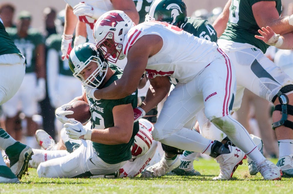Senior tight end Josiah Price (82) is tackled by Wisconsin defensive end Alec James (57) during the game against Wisconsin on Sept. 24, 2016 at Spartan Stadium. An unsportsmanlike conduct penalty was called against the Badgers.
