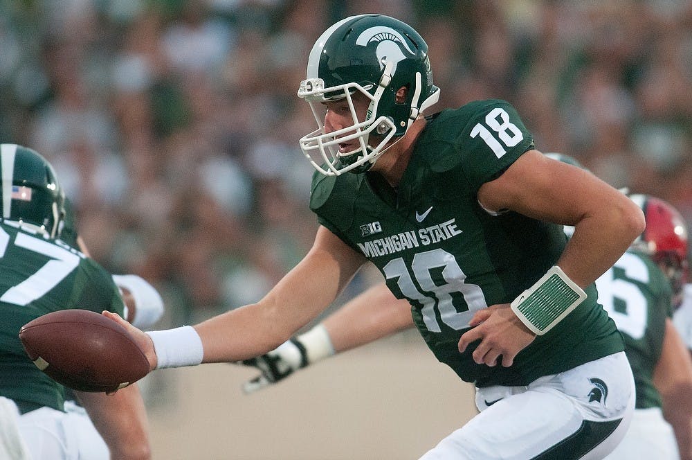 <p>Junior quarterback Connor Cook hands off the ball during a game against Jacksonville State on Aug. 29, 2014, at Spartan Stadium. The Spartans defeated the Gamecocks, 45-7. Julia Nagy/The State News</p>