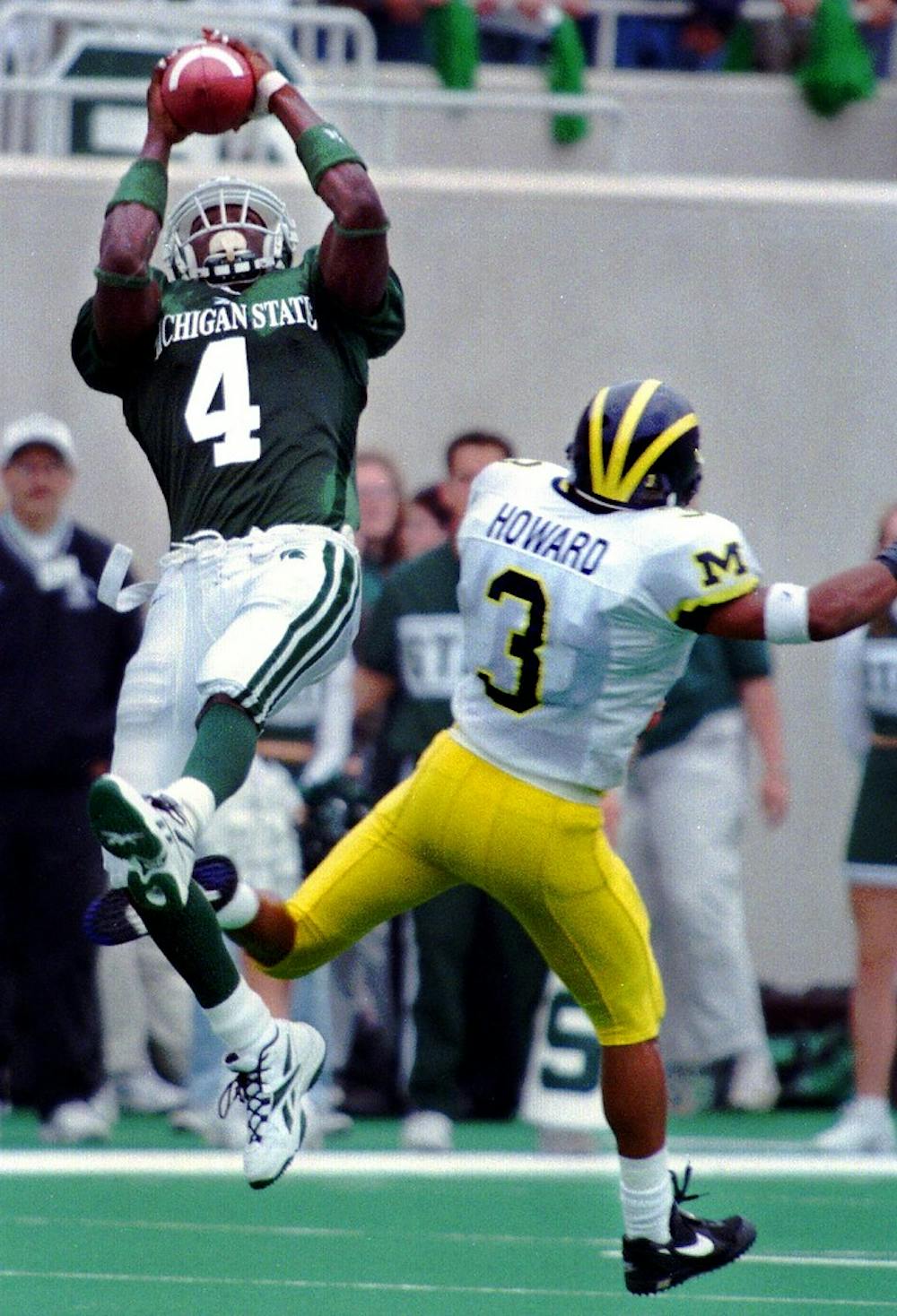 <p>MSU junior wide receiver Plaxico Burress (4) catches the ball over Michigan's cornerback Todd Howard on Oct. 10, 1999, at Spartan Stadium. The Spartans beat the Wolverines 34-31. Cory Morse/The State News</p>