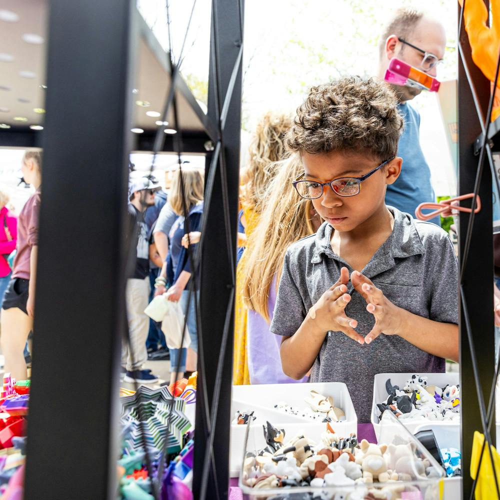 <p>A young customer looks over a selection of 3D printed figures at a booth during the 63 annual East Lansing Art Festival in East Lansing, Mich., on May 16, 2026.</p>