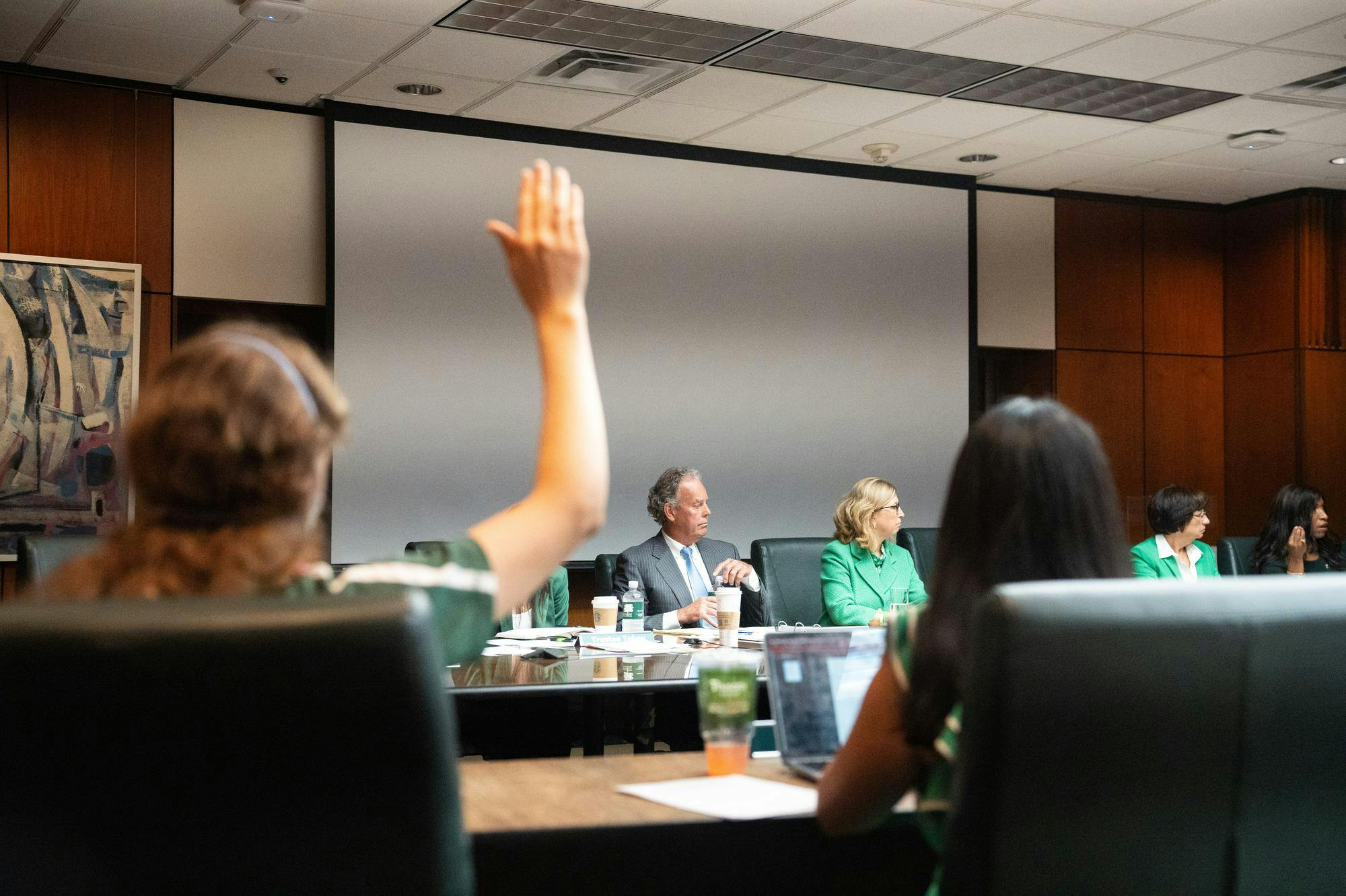 Student Liaison Hannah Jeffery raising her hand to ask a question at the Board of Trustees Meeting at the Hannah Administration Meeting on Sep. 8, 2023.