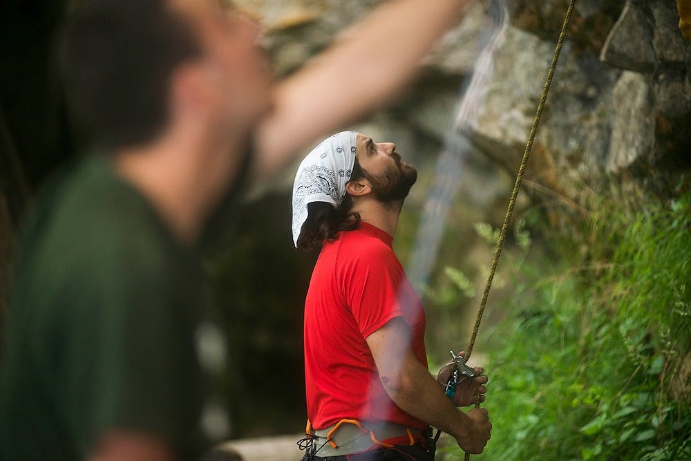 <p>Masters student Joel Anderson belays a climber during an outing with the MSU Outdoors Club on June 10, 2014, at Oak Park in Grand Ledge, Mich. Anderson has been climbing for a year and a half. </p>