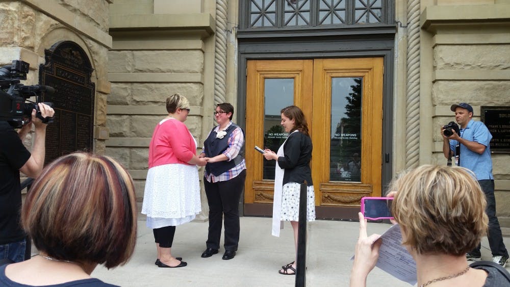 <p>Rev. Nicolette Siragusa officiates a same-sex marriage on the steps of the Ingham County Clerk's office on Friday, June 26, 2015. </p>