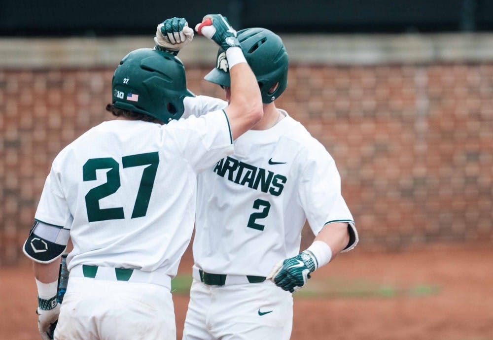 Junior catcher Nic Lacayo (27) celebrates with Junior infielder Marty Bechina (2) for Bechina's homerun at McLane Baseball Stadium on April 13, 2018. The Spartans fell to the Crusaders, 7-6.(Annie Barker | State News)