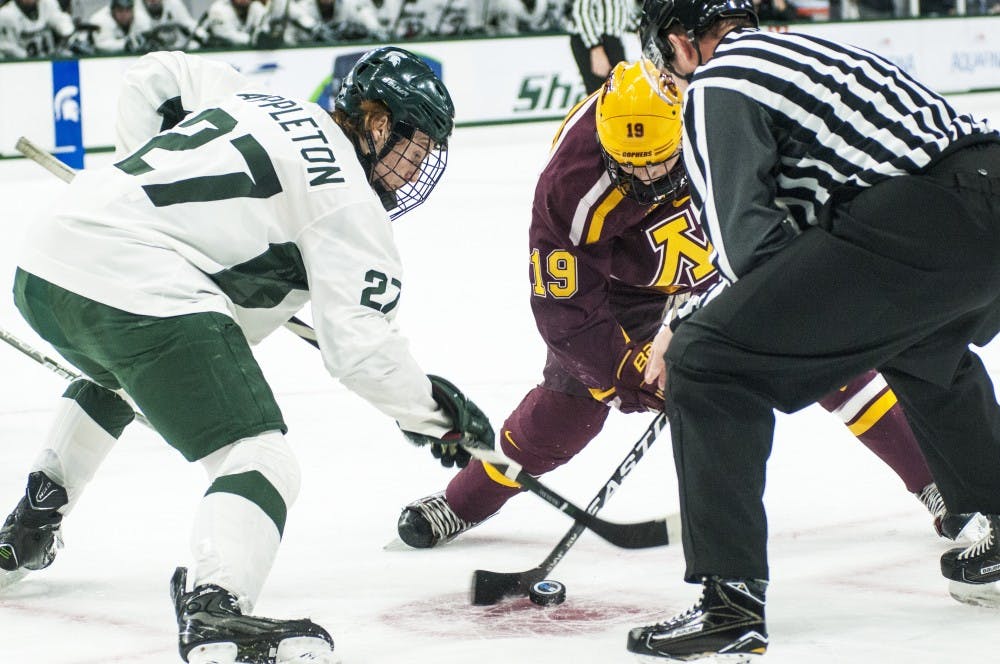 Sophomore wingman Mason Appleton (27) and Minnesota wingman Vinni Lettieri (19) face off during the first period in the game against Minnesota on Dec. 9, 2016 at Munn Ice Arena. 