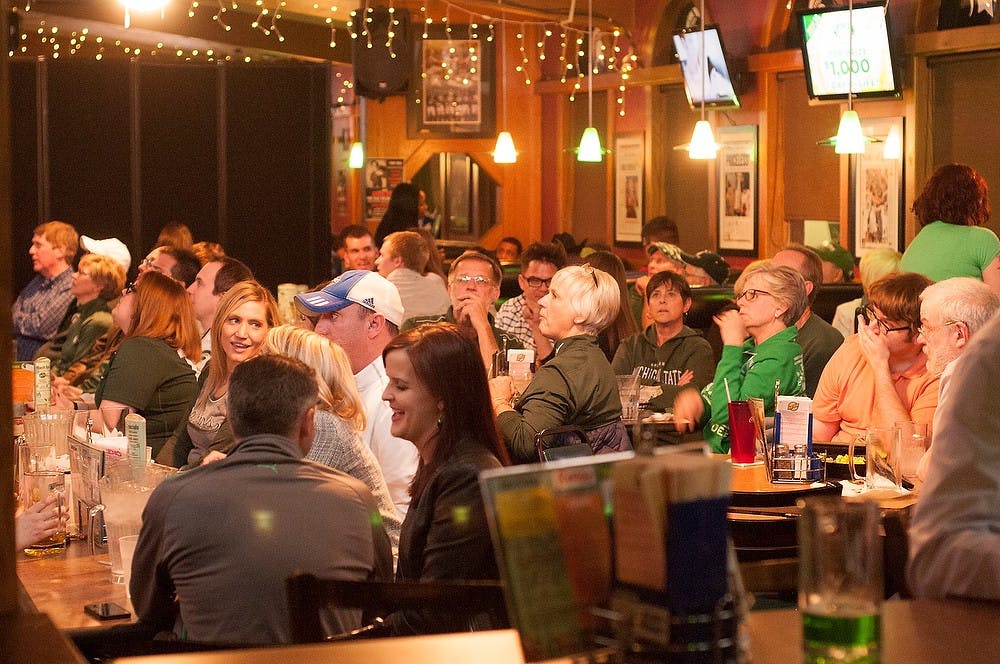 <p>Students and alumni watch the men's basketball game against Ohio State Mar. 13, 2015, at Reno's Sports Bar, 1310 Abbot Rd. Reno's is a popular place for students and alumni who couldn't travel to Chicago to watch the Big Ten tournament to enjoy the game. Alice Kole/The State News</p>