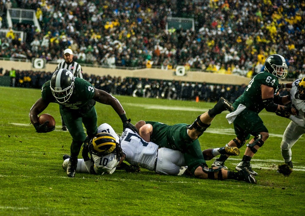 Senior running back LJ Scott (3) get's taken down by Michigan's junior linebacker Devin Bush (10) during the game against Michigan on Oct. 20, 2018 at Spartan Stadium. The Spartans fell to the Wolverines, 21-7.
