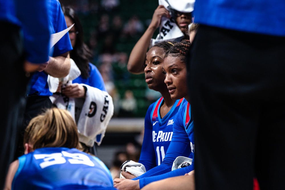 DePaul junior guard Taylor Johnson-Matthews (0) and sophomore guard Sumer Lee (11) listen to their coach in the time out circle at the Breslin Center on Dec. 8, 2024. The Spartans won 89-61 against the Blue Demons, starting the season 9-0 for the first time in program history. 