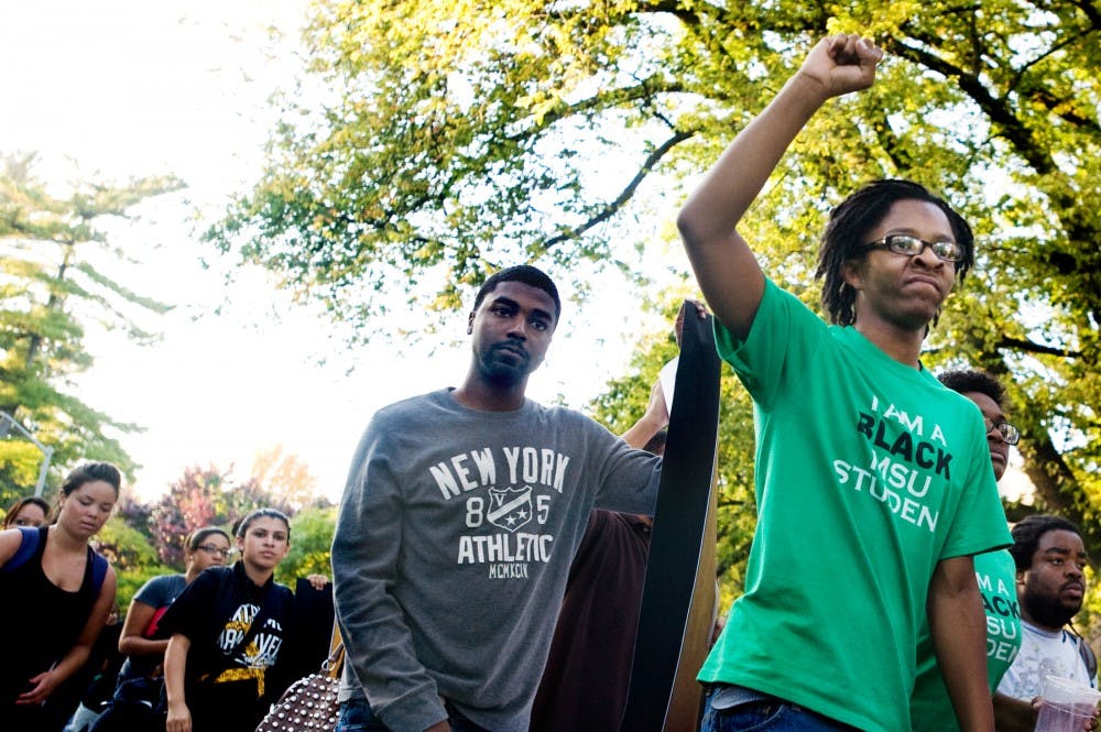 Then-education senior and BSA president Mario Lemons, far right, raises his fist during the silent march and protest rally hosted by the Black Student Alliance and Iota Phi Theta fraternity on October 6, 2011 in reaction to a string on racial incidents that occurred on campus. State News File Photo