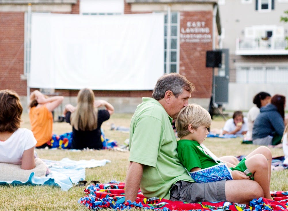 	<p>East Lansing resident Blair Renfro kisses the head of his son, Wyatt Renfro, 6, while they wait for the movie to begin Thursday night at the Moonlight Film Festival held at Valley Court Park. An outdoor movie will be shown every Thursday through August.</p>