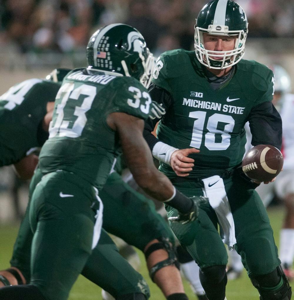 <p>Junior quarterback Connor Cook hands the ball to senior running back Jeremy Langford during the game against Ohio State on Nov. 8, 2014, at the Spartan Stadium. The Buckeyes defeated the Spartans, 49-37.  Aerika Williams/The State News </p>