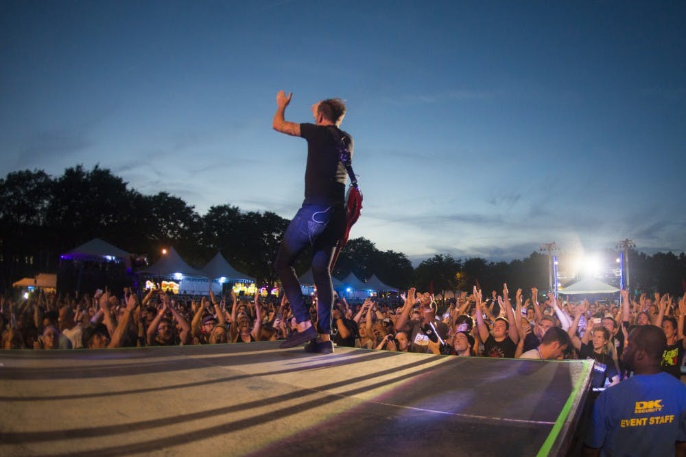 <p>Tim McIlrath of Rise Against encourages the crowed to clap during Common Ground Music Festival on July 6, 2016 at Adado Riverfront Park in Lansing. McIlrath has been rhythm guitar for Rise Against since 1999.</p>