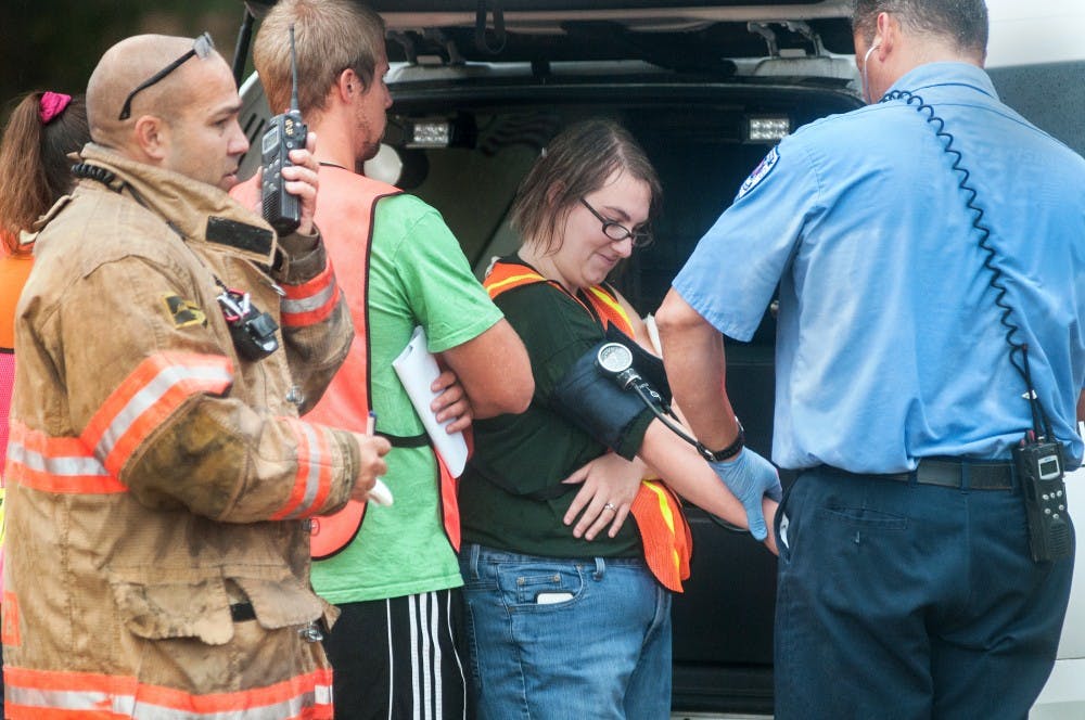 Emergency responders and volunteers simulate an emergency outside of Conrad Hall Wednesday, July 18, 2012.  The full-scale exercise was designed to prepare first responders for an actual incident. Adam Toolin/The State News