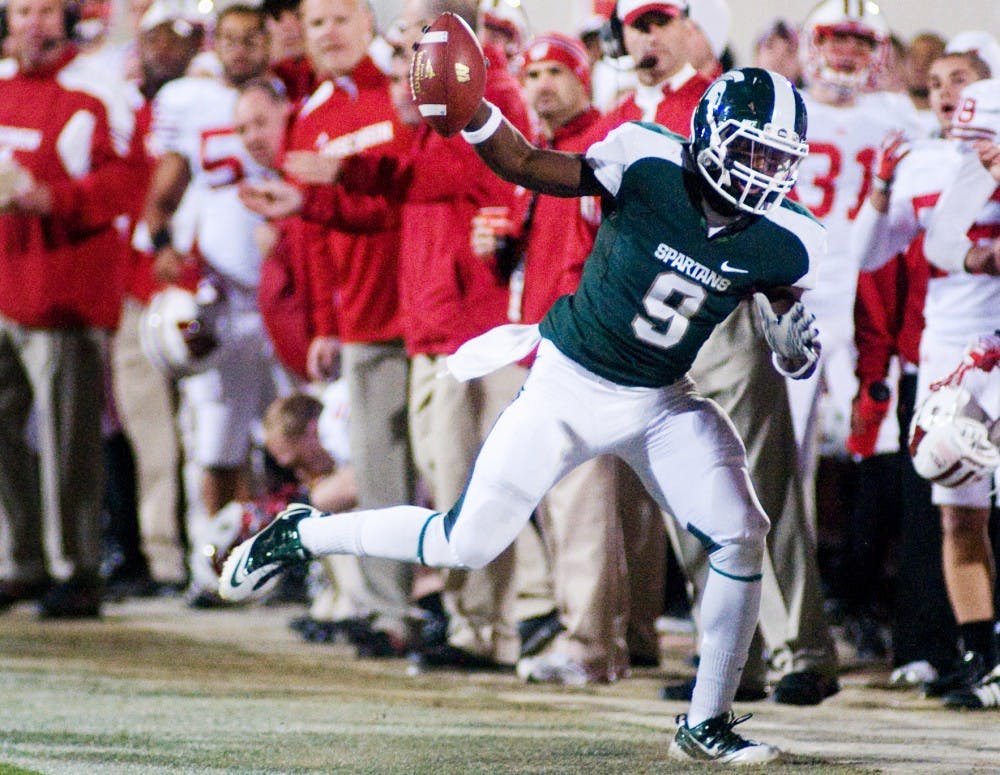 Sophomore safety Isaiah Lewis holds out an intercepted ball as he steps out of bounds Saturday at Spartan Stadium. The Spartans defeated the Wisconsin Badgers 37-31. Matt Radick/The State News