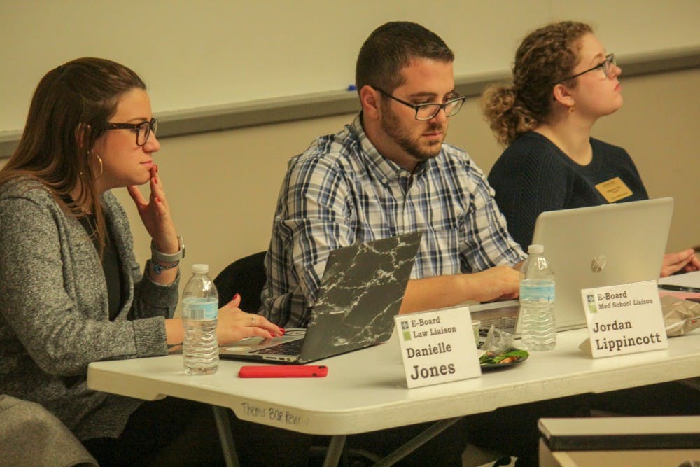 E-Board Law Liaison Danielle Johns, left, and E-Board medical School Liaison Jordan Lippincott, right, listen at a COGs meeting in the Law College on Feb. 13, 2019.