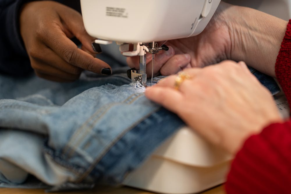 <p>MSU archivist Susan O&#x27;Brien works with an attendee to patch a ripped pair of jeans, at the MSU Library&#x27;s Clothing Repair-A-Thon on Tuesday, November 15th, 2022.</p>