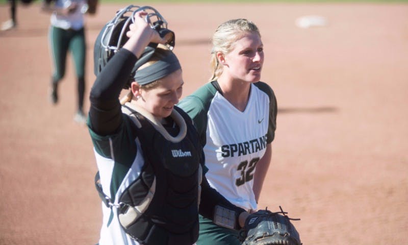 <p>Sophomore Bridgette Rainey, right, and sophomore catcher Jordan Davis walk to the dugout during the game against Broncos on March 29, 2016 at Secchia Softball Stadium. The Spartans defeated the Western Broncos, 12-2.</p>