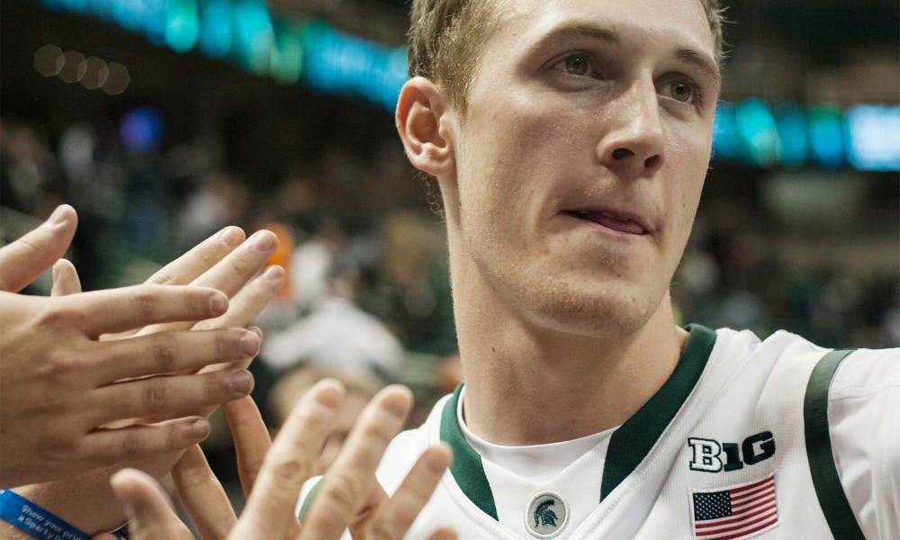 Sophomore forward Colby Wollenman high fives fans at the end of the game against Indiana University of Pennsylvania, Nov. 4, 2013, at Breslin Center. The Spartans won, 83-45. Danyelle Morrow/The State News