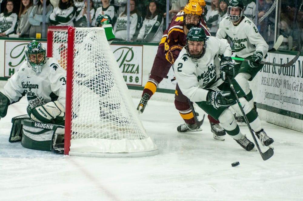 Senior right defense Zach Osburn (2) cuts around the goal during the game against Minnesota on Jan. 19, 2019 at Munn Ice Arena. The Spartans defeated the Gophers, 5-3.