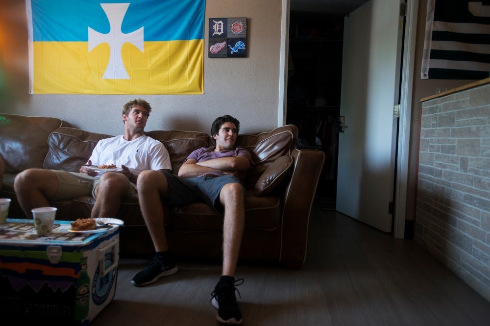 <p>Kinesiology sophomore David Wright, left, and computer science sophomore Jack Mansueti relax in a living room on Sept. 2, 2015, at Sigma Chi House, 729 E. Grand River, in East Lansing. The house has undergone many renovations, including redoing the bedrooms and living areas. </p>