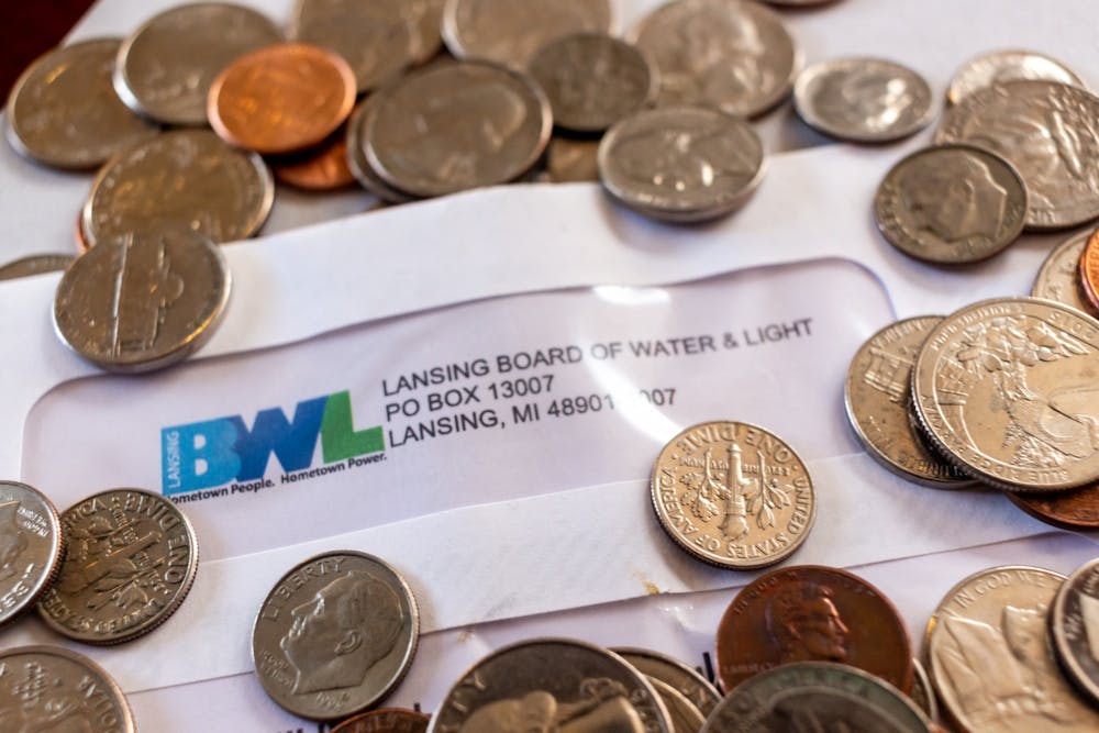 Coins and a Lansing Board of Water and Light bill photographed on April 7, 2020.