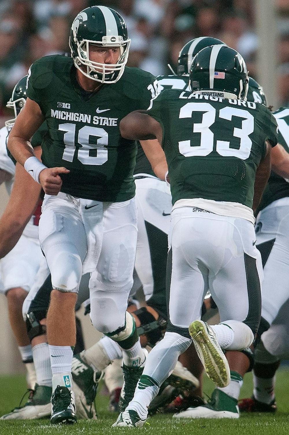 <p>Junior quarterback Connor Cook hands the ball off to senior running back Jeremy Langford during the game against Jacksonville State on Aug. 29, 2014, at Spartan Stadium. The Spartans defeated the Gamecocks, 45-7. Julia Nagy/The State News</p>