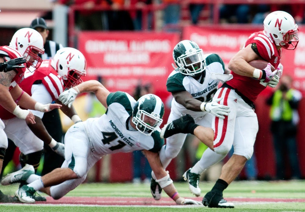 Senior safety Trenton Robinson and sophomore linebacker Kyler Elsworth can't tackle running back Rex Burkhead as he slips by on a run. The Cornhuskers defeated the Spartans, 24-3, on Saturday afternoon at Memorial Stadium in Lincoln, Neb. Josh Radtke/The State News