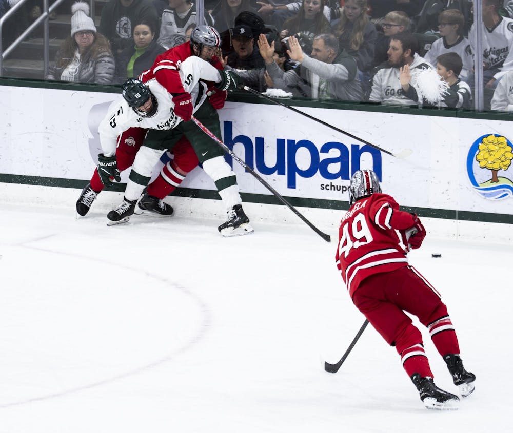 <p>MSU senior forward Charlie Stramel (15) holds off OSU players from getting to the puck in the Munn Ice Arena on March 14, 2026.</p>